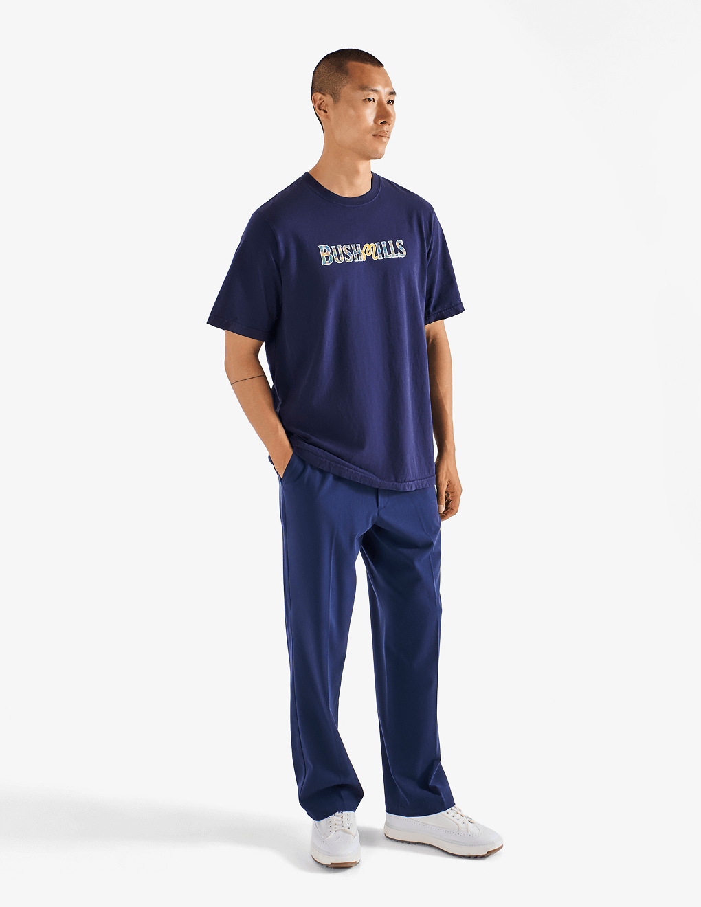 Model wearing of Bushmills x Malbon navy t-shirt, showing front of shirt.
