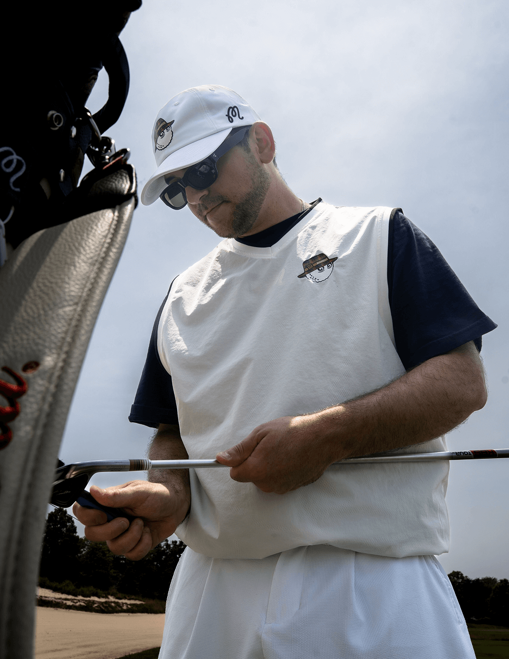 Man wearing Bushmills x Malbon white vest on golf course.