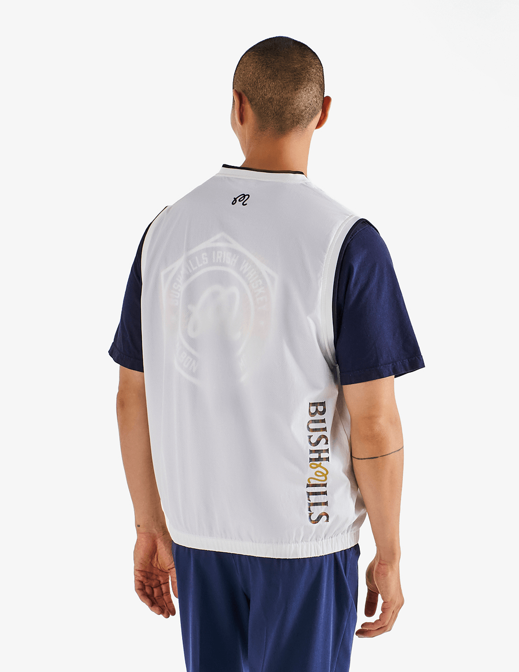 Male modeling back of Bushmills x Malbon woven white vest.