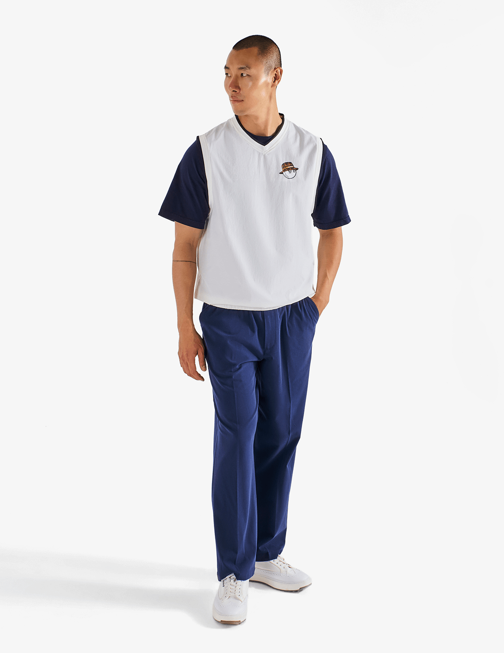 Male modeling front of Bushmills x Malbon woven white vest.