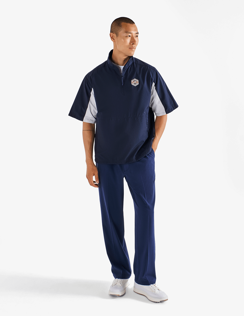 Male modeling front of Bushmills x Malbon navy windshirt.