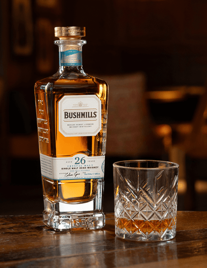 Bushmills 26 Year with neat pour on a table.