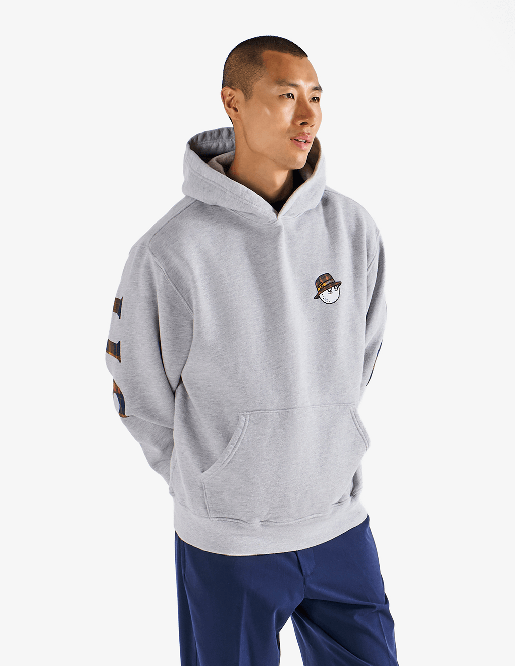 Model wearing of Bushmills x Malbon gray hoodie, showing front of hoodie.