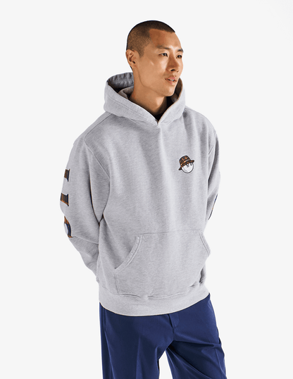 Model wearing of Bushmills x Malbon gray hoodie, showing front of hoodie.