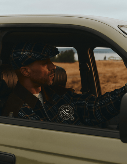 Bushmills X Malbon Wool & Leather Jacket on a model in a car on the golf course.