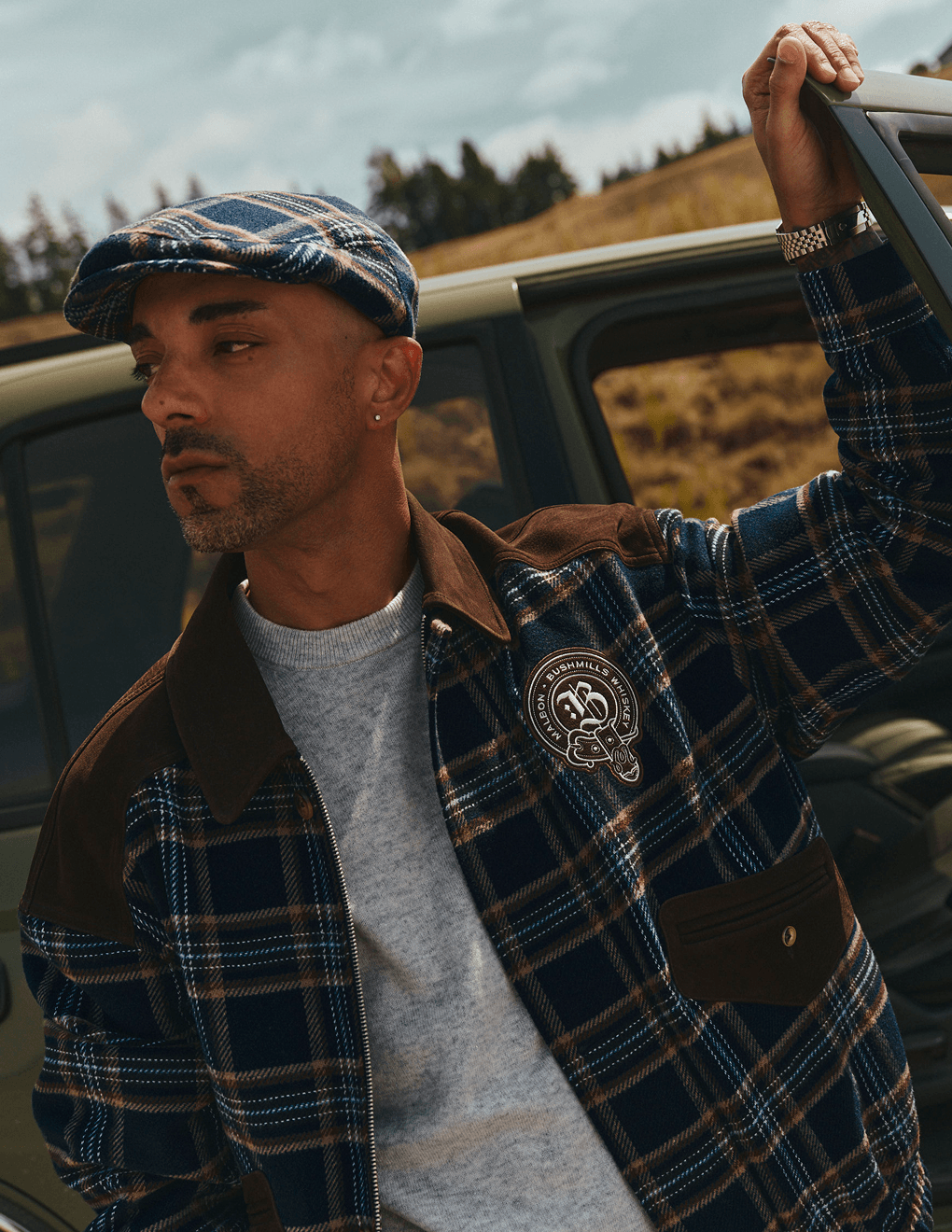 Bushmills X Malbon Wool & Leather Jacket on a model getting out of a car on the golf course.
