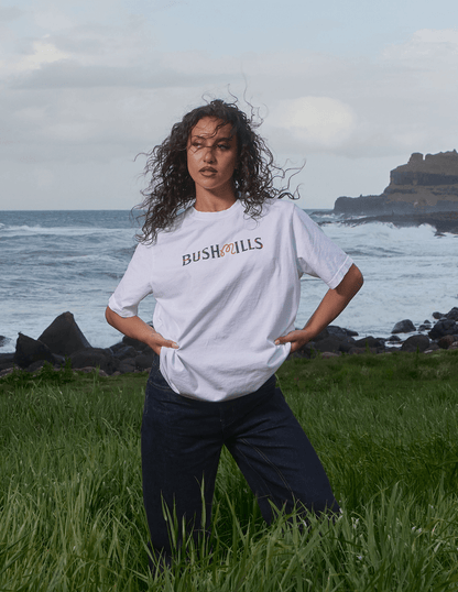 Front of Bushmills x Malbon white tee on model on a cliff by Irish seas.
